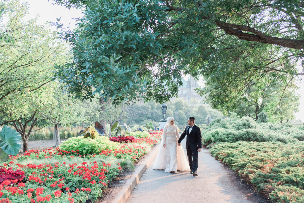 bride & groom strolling infront of parliament hill