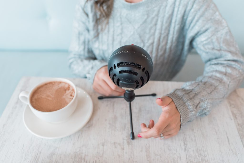 good podcasts to listen to, top favourite podcasts, 8 podcasts to listen to. Podcaster with microphone and coffee